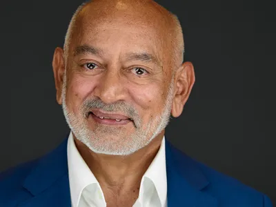 Distinguished executive with grey beard in royal blue blazer and white shirt, confident expression