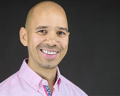 Modern business headshot with professional styling against dark studio background