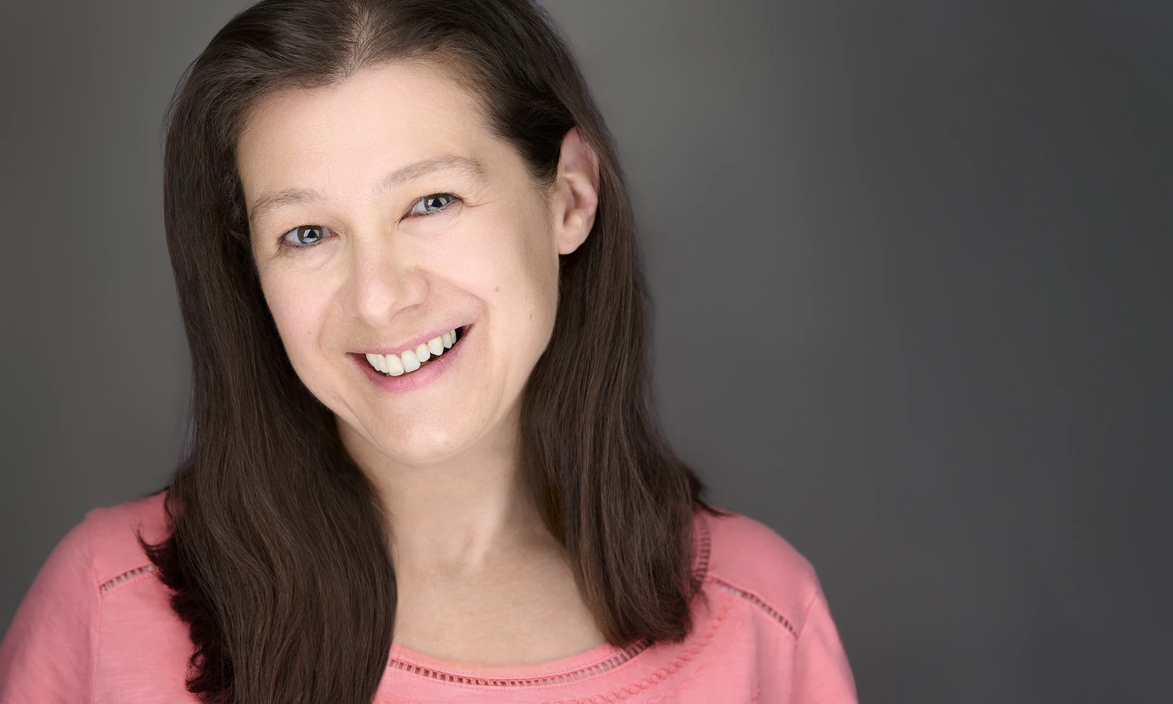 Profile images of business women wearing a pink blouse with long brown hair