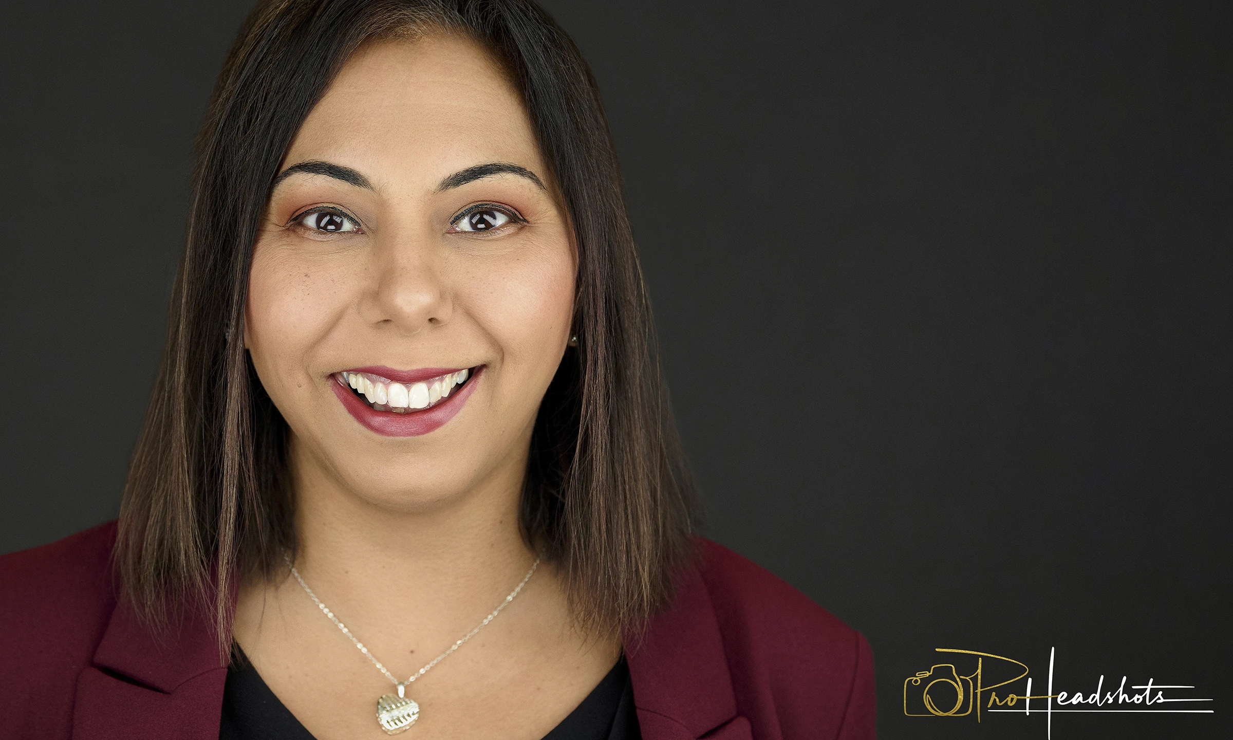 Corporate headshots for companies, executive wearing dark red suit