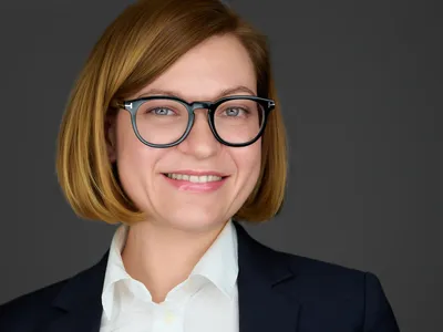 Confident Devon professional with warm smile in studio-lit business portrait