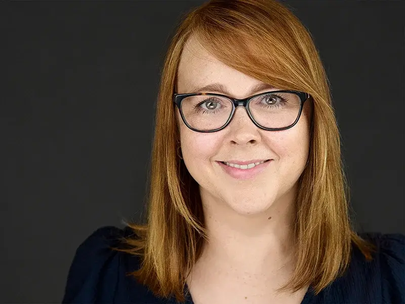 Exeter businesswoman in a blue top smiling naturally - showcasing our portrait lighting style.