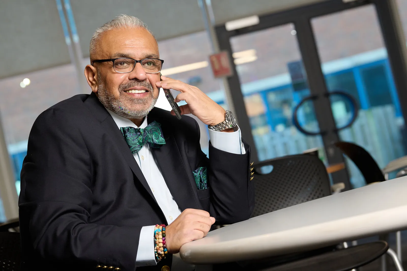 Christian in a formal boardroom setting, reviewing financial documents with focused attention