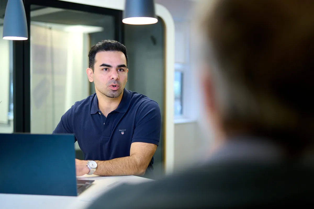 Professional in discussion across a table with a client during a meeting