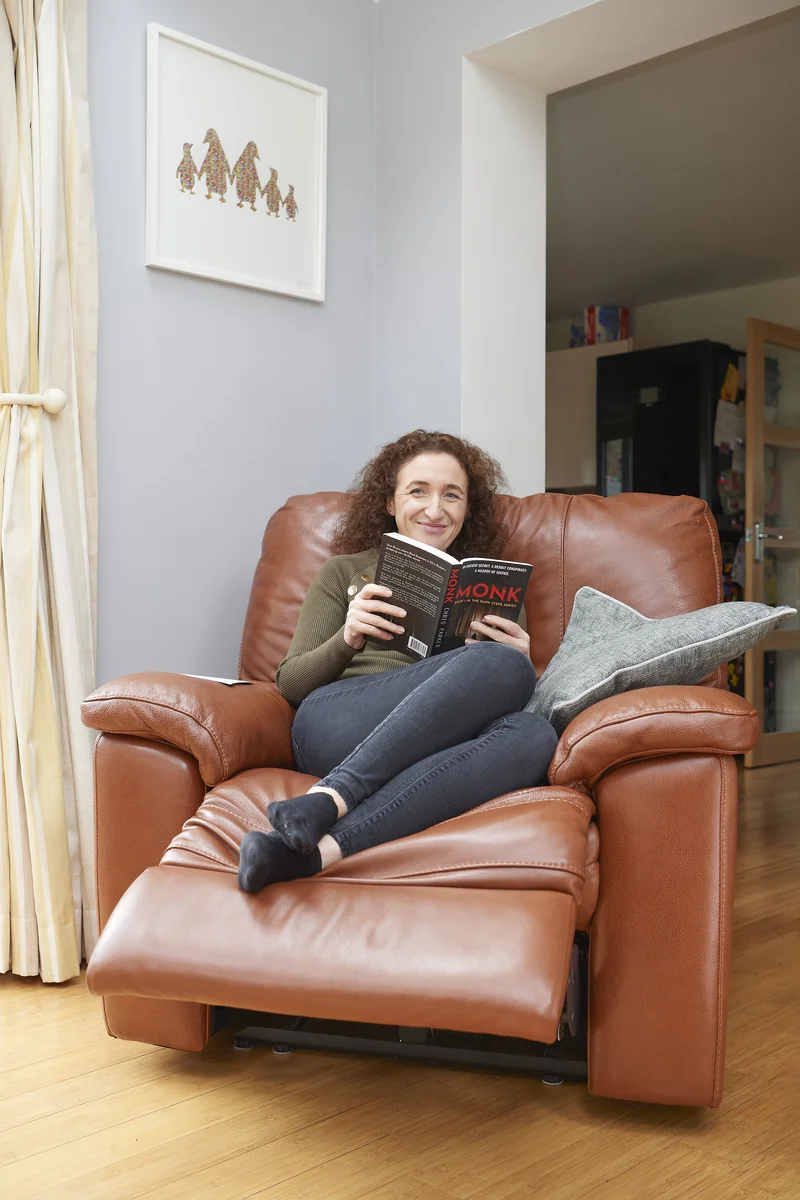 Lizzie Butler relaxed at home in an armchair, reading a book, completely off duty