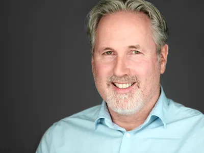 Corporate headshot with professional styling and approachable expression