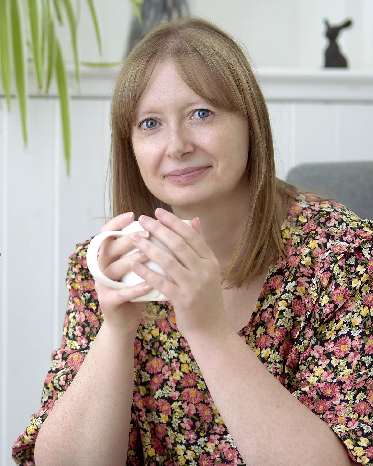 Professional Business Portrait of a woman designer, she is holding a mug of coffee