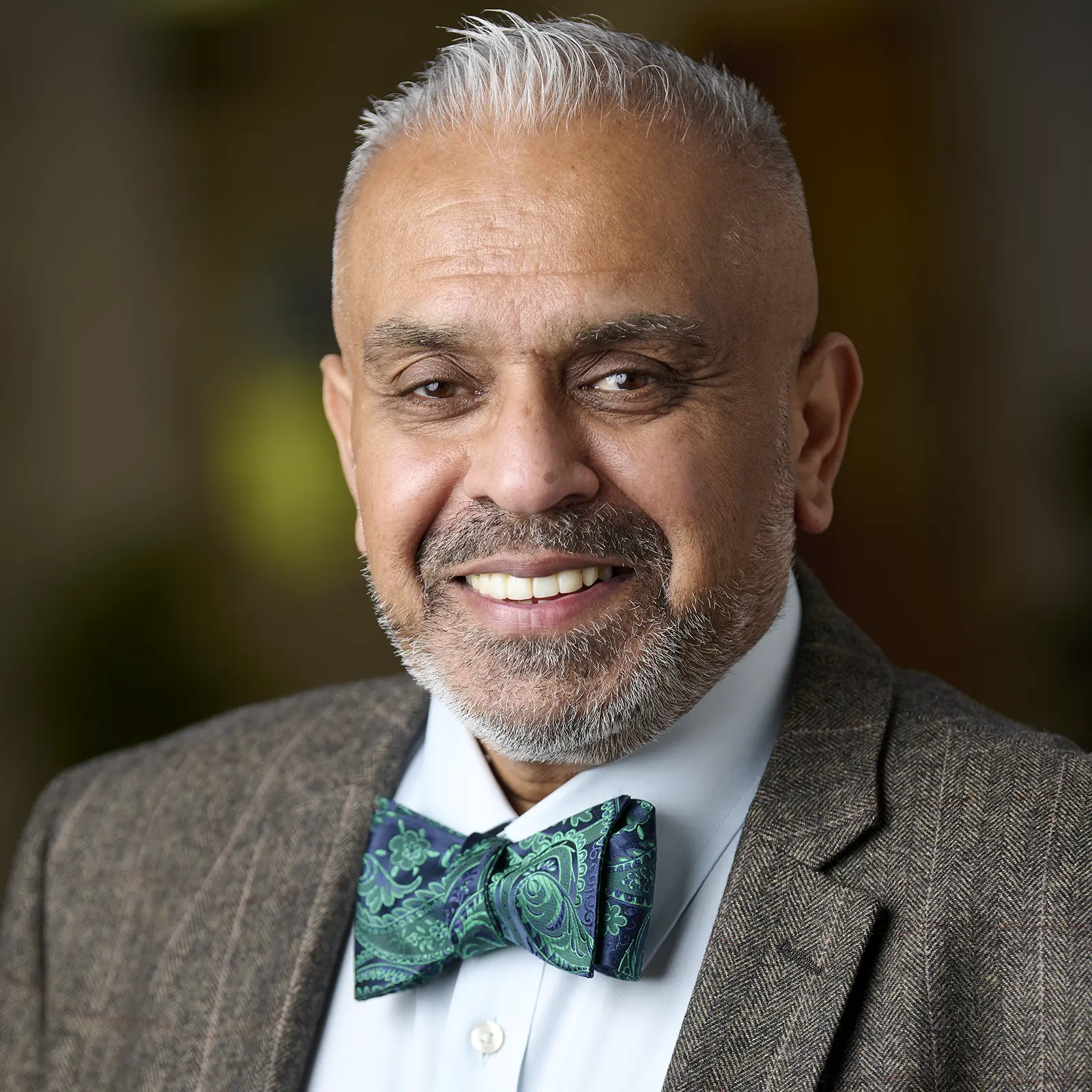 Professional corporate headshot of a man in a bow tie and suit. Captured at your workplace