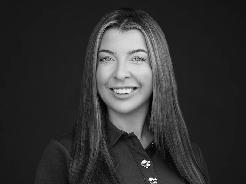 Black and white headshot of a young woman on a dark background