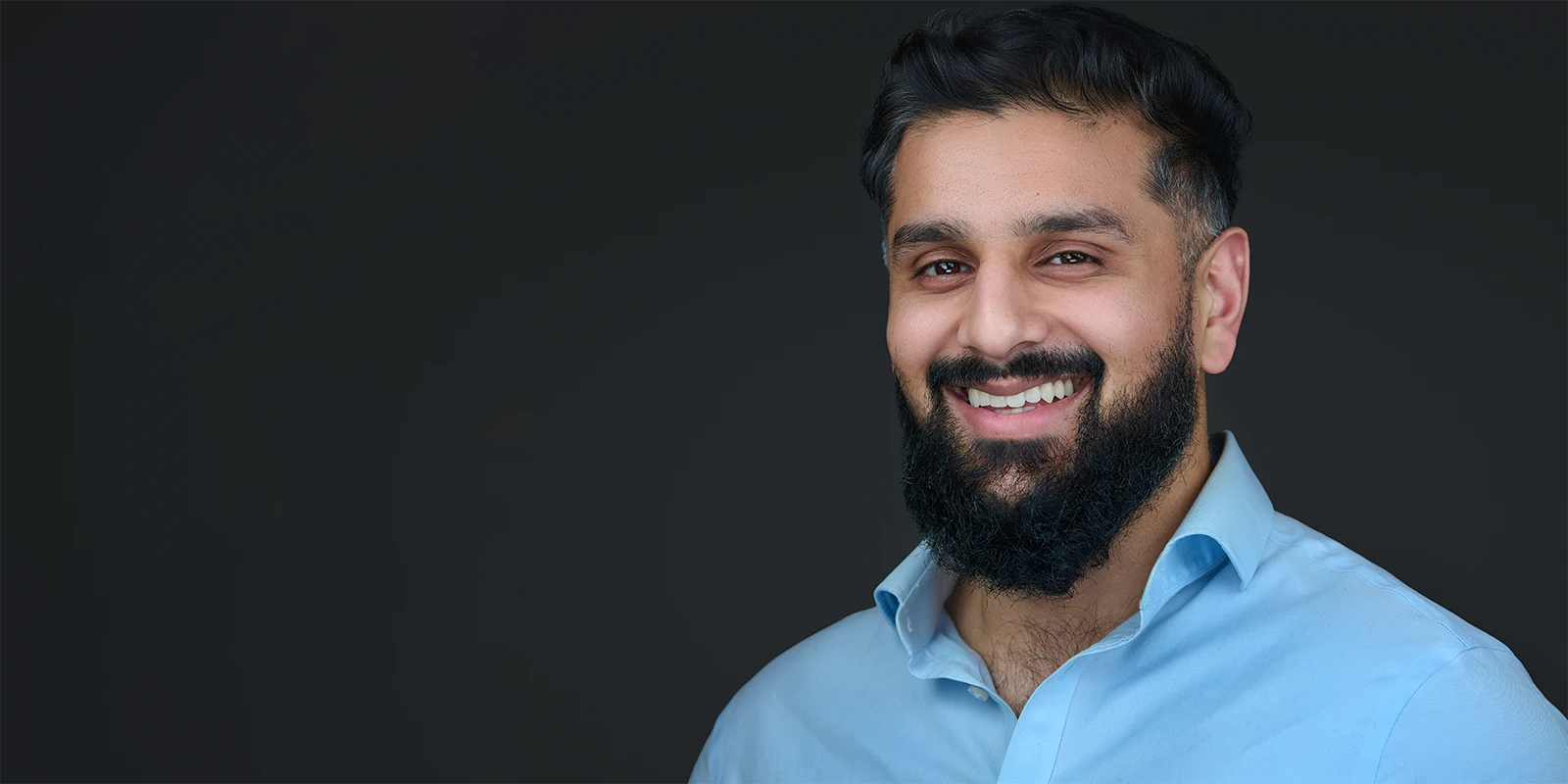 Genuine professional headshot showing authentic expression — not AI-generated