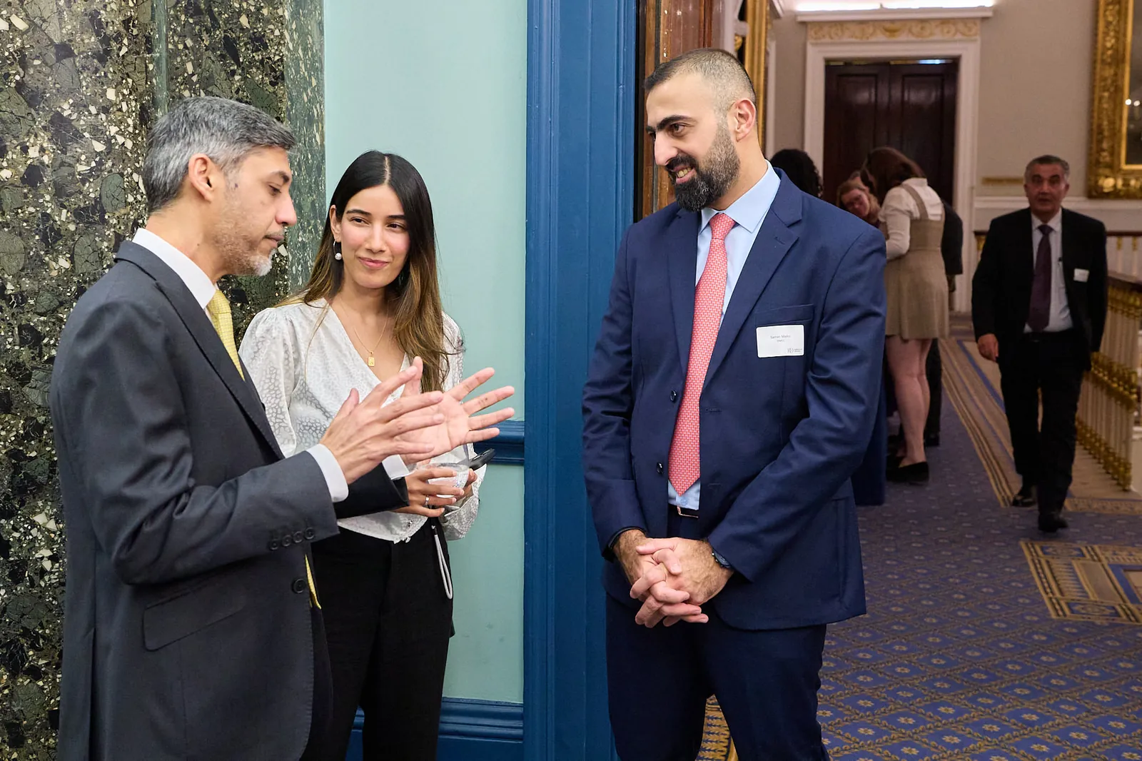 Three guests in conversation beside a marble column at 116 Pall Mall during the networking at Made for Trade Live London