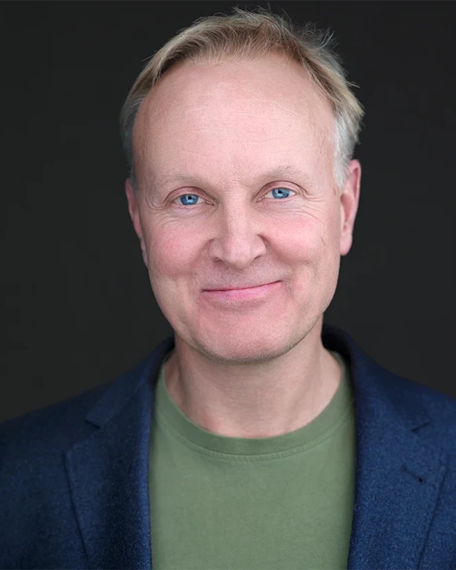 Photographer using expression and posture coaching during a professional headshot session