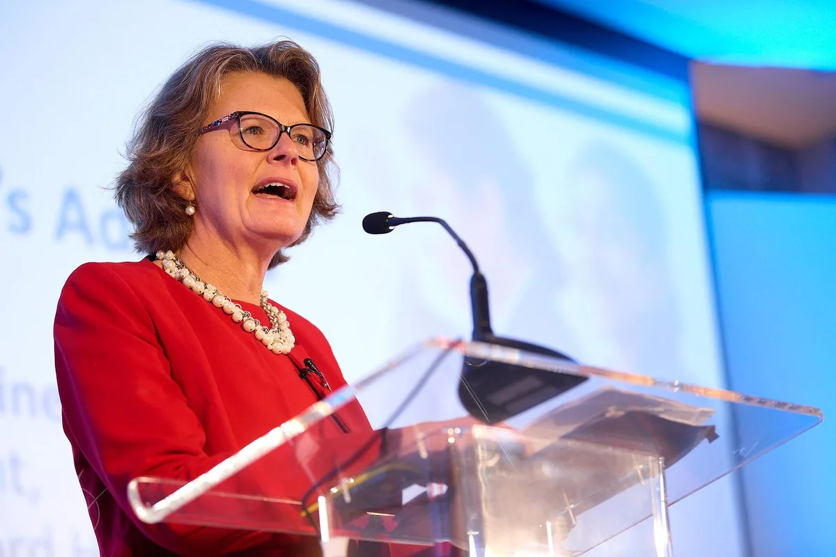 Speaker at a formal podium delivering a keynote address to a professional audience