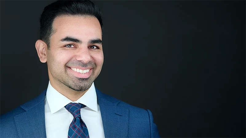 Ben Rahmani compliance consultant headshot, confident and warm expression on a dark background
