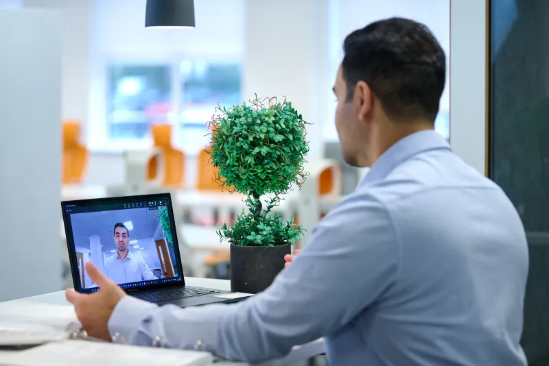 Ben Rahmani on a video call at YourSpace Bournemouth, bright communal office setting