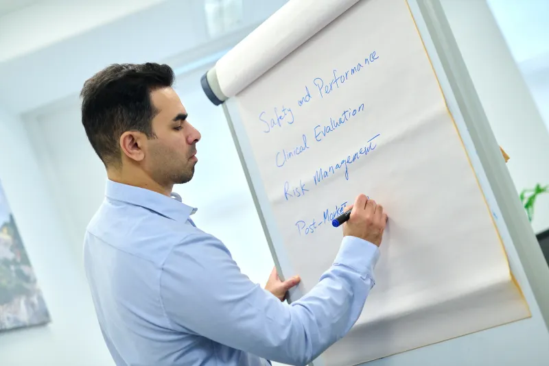Ben Rahmani writing compliance notes on a flipchart, personal branding session at YourSpace Bournemouth