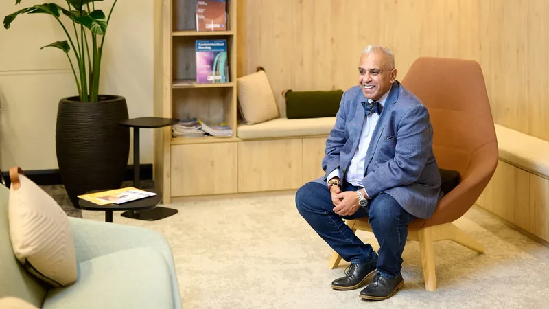 Christian Kumar seated and focused, reviewing notes ahead of a boardroom presentation