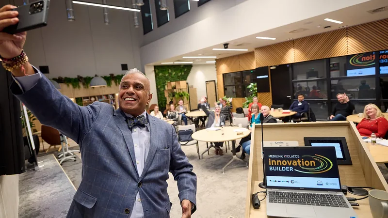 Christian Kumar taking a selfie with his audience in the background at the end of a talk
