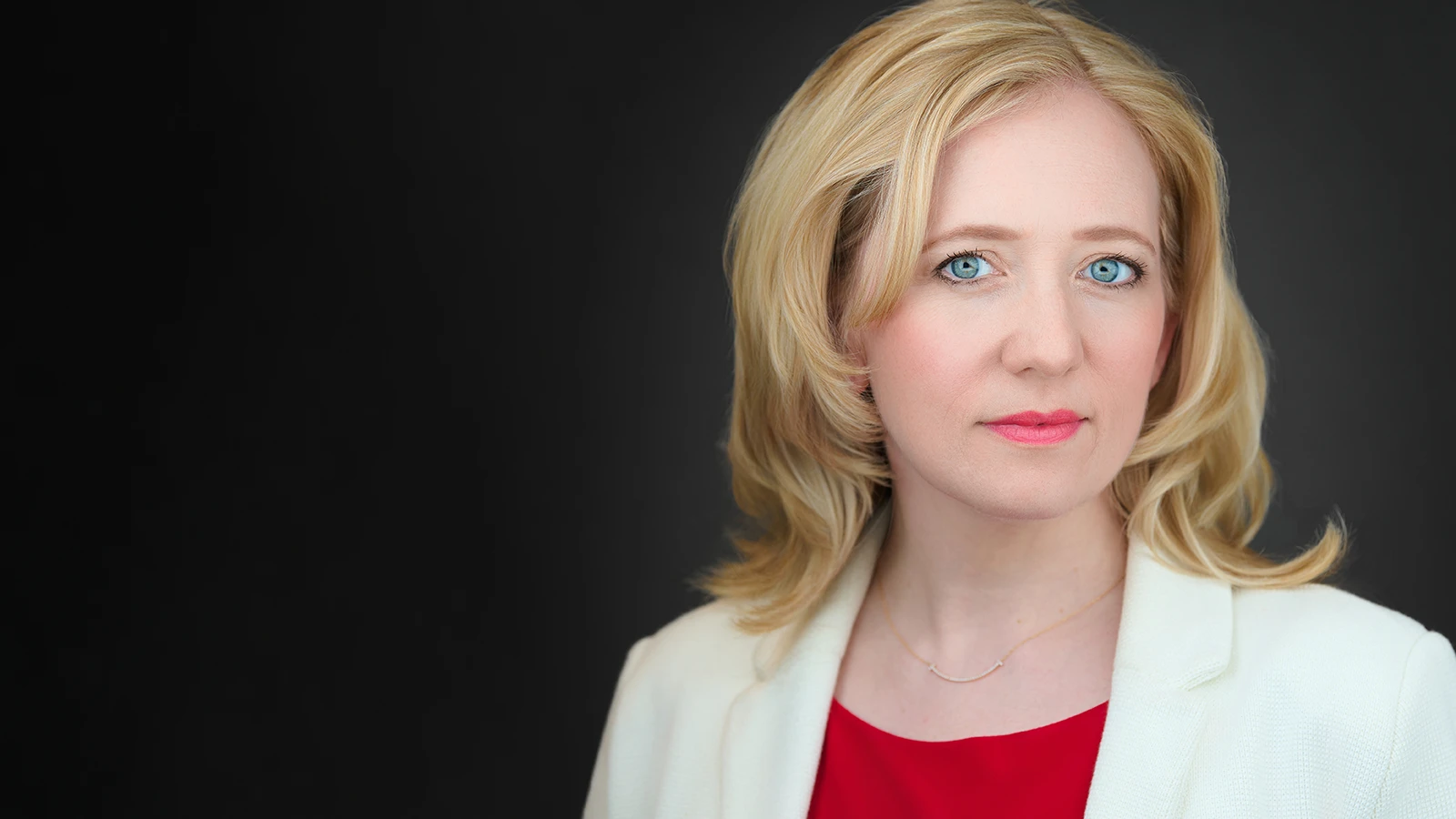Woman with blonde hair in white blazer and red top, confident expression, Bath headshot photographer