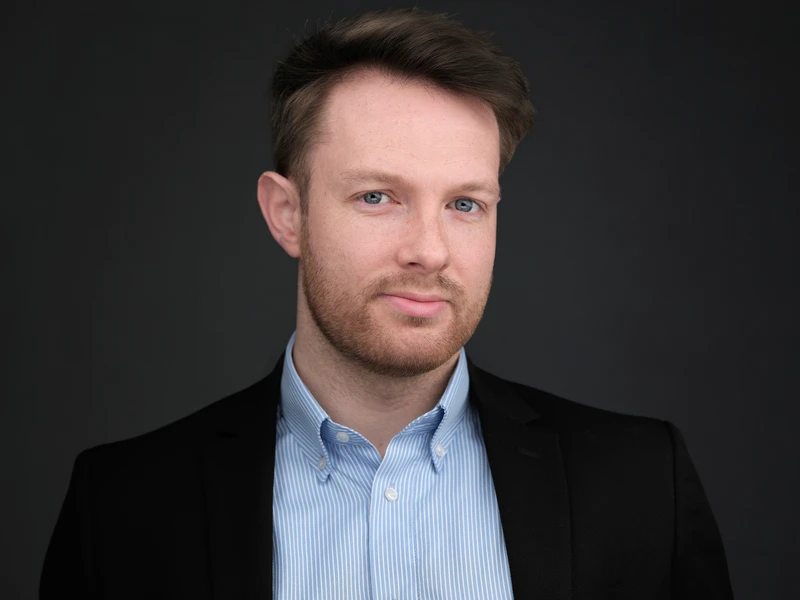 Man in a blazer and dress shirt, confident and direct look to camera
