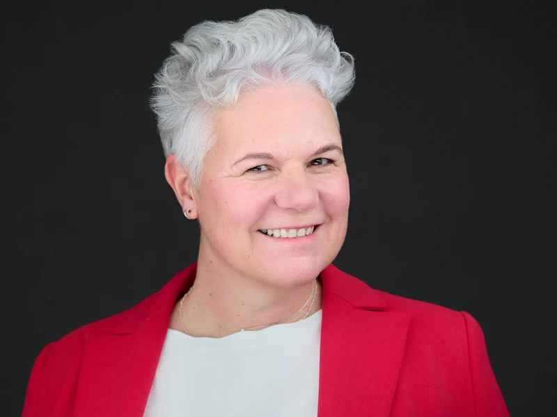 Corporate headshot of a woman in a dark blazer, warm and composed professional portrait
