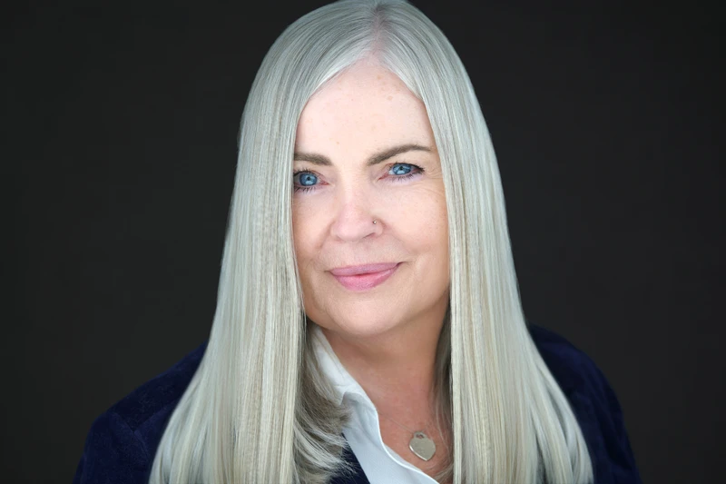 Woman in blazer and dress shirt, composed and confident professional portrait